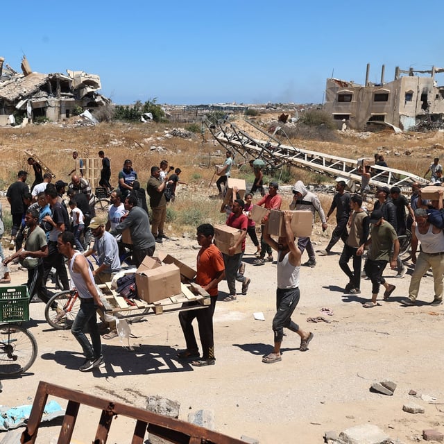 People carry boxes of relief supplies from the Gaza Humanitarian Foundation in the central Gaza Strip on May 29. The RCMP says it has a protocol to triage and process information related to global conflicts as a standard initial procedure.