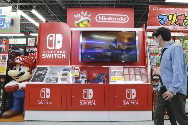 FILE – A man walks by a Nintendo Switch display at an electronics retail chain store in Tokyo, on Oct. 13, 2021. (AP Photo/Koji Sasahara, File)