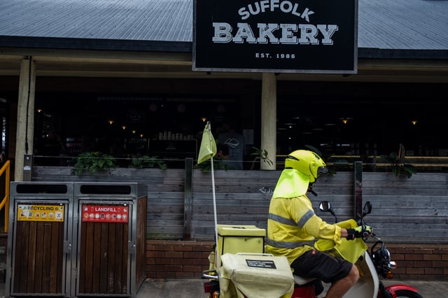 BYRON BAY, AUSTRALIA - FEBRUARY 14: An Australian Postal worker parks a bike outside Suffolk Bakery in Suffolk Park on February 14, 2023 in Byron Bay, Australia. Byron Bay, NSW is the easternmost point of the Australian mainland, and is one of the best-known beach towns and tourist destinations, according to Encyclopedia Brittanica. The greater area of Byron Shire is well known by both domestic and international visitors for surfing, snorkeling, hiking and camping, with many people traveling around the area in camper vans. According to a ‘Tourism Resilience COVID-19 Report’ by the Byron Shire municipal council, in 2019 a total of 2.41 million people visited. The report estimates that Byron Shire will not see those numbers until at least 2024, with international numbers not returning for at least 10 years. (Photo by Alexi Rosenfeld/Getty Images)