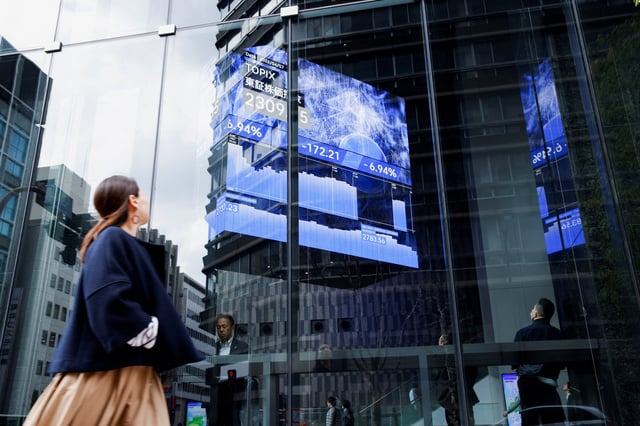 A woman walks past a stock quotation board at a brokerage in Tokyo, Japan, April 7, 2025. REUTERS/Androniki Christodoulou/File Photo