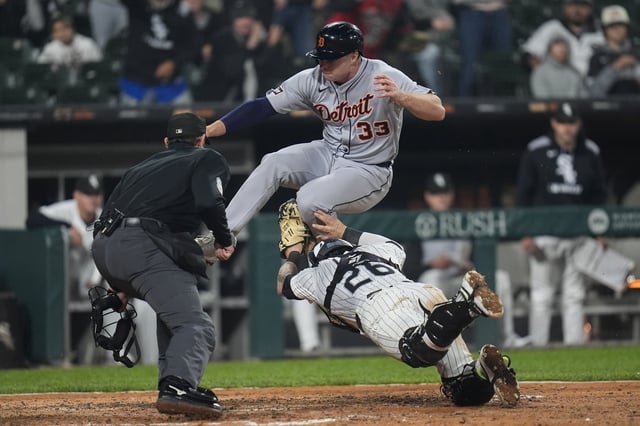 Detroit Tigers designated hitter Colt Keith (33) jumps over Chicago White Sox catcher Korey Lee (26) but is tagged out at home during the eighth inning of a baseball game Wednesday, June 4, 2025, in Chicago. (AP Photo/Erin Hooley)