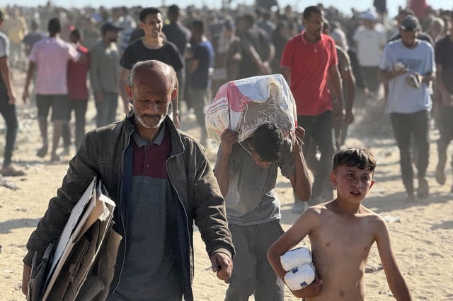 Des Palestiniens déplacés reçoivent de l’aide humanitaire à l’ouest de Rafah, dans le sud de la bande de Gaza, le 27 mai 2025.