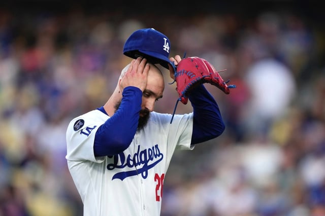 Dodgers starting pitcher Tony Gonsolin wipes his head as he walks off the field after giving up three runs in the top of the first inning of their 6-1 loss to the New York Mets on Wednesday night at Dodger Stadium. (AP Photo/Mark J. Terrill)