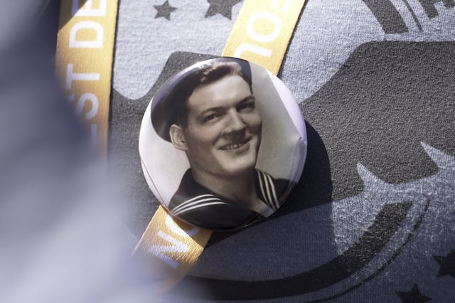 A black and white photo that Kara Houser, the granddaughter of a World War II veteran, pinned to her chest during a visit on Monday, June 2, 2025 in Colleville-sur-Mer, to the Normandy American Cemetery shows Fred Mitchell Shafer, who Houser said served aboard one of the landing craft that deposited American soldiers on Omaha Beach during the June 6, 1944, D-Day invasion of Nazi-occupied France (AP Photo/John Leicester)