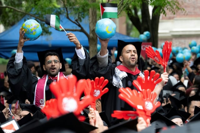 Des étudiants diplômés brandissent des drapeaux palestiniens à l'université Harvard Yard, à Cambridge (Massachusetts), aux Etats-Unis, le 29 mai 2025