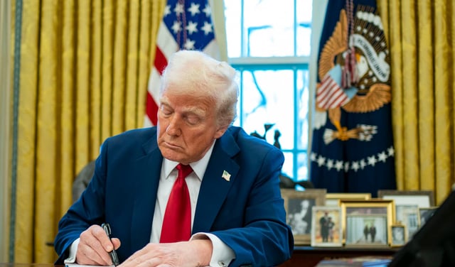US President Donald Trump signs an executive order in the Oval Office of the White House in Washington, D.C., US, on Thursday, Jan. 30, 2025.