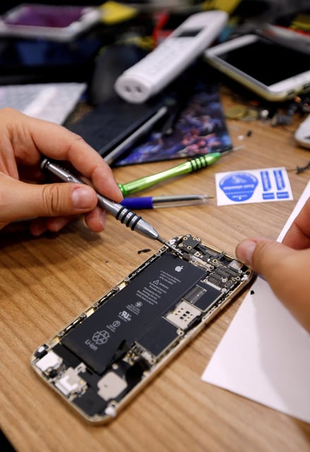 A technician repairs an iPhone in a repair shop in Marseille, France, July 3, 2017.   REUTERS/Jean-Paul Pelissier/File Photo