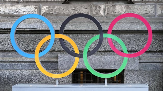 Olympische Ringe vor einer Hauswand