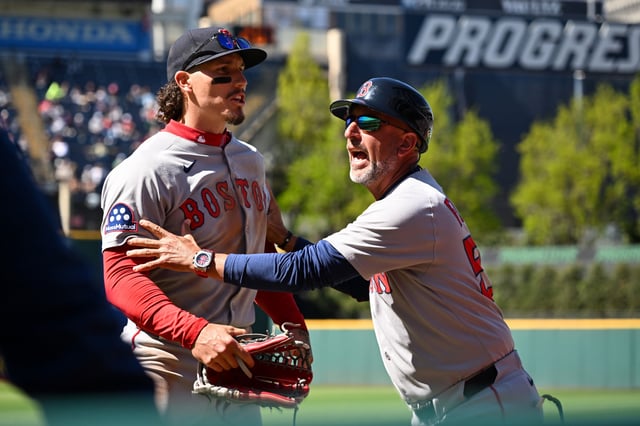 CLEVELAND, OHIO - APRIL 27: First base coach José David Flores #58 of the Boston Red Sox holds back Jarren Duran #16 as Duran yells at a fan during the seventh inning against the Cleveland Guardians at Progressive Field on April 27, 2025 in Cleveland, Ohio.