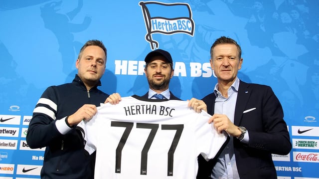 777 Partners und Hertha-Verantwortliche Kay Bernstein und Thomas Herrich halten Trikot