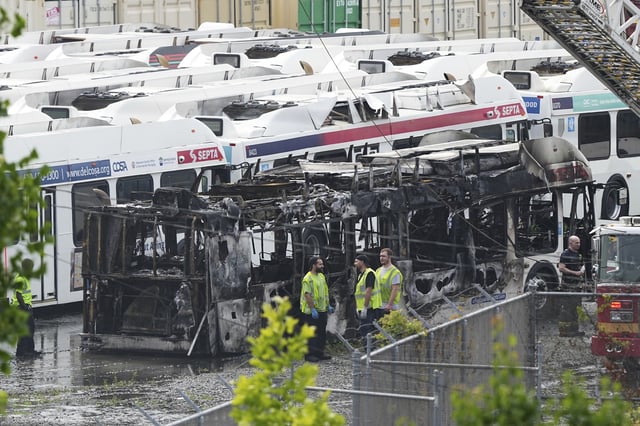 Officials inspect the burnt wreckage of a bus at Southeastern Pennsylvania Transportation Authority facility in Philadelphia, Thursday, June 5, 2025. (AP Photo/Matt Rourke)