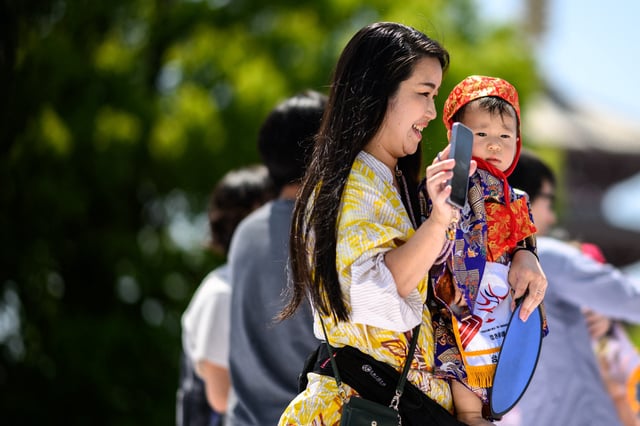 A mother takes her child to take part in the &#34;crying baby sumo&#34; match at Sensoji temple in Tokyo on April 28, 2024.