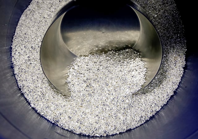 An employee takes granules of 99.99 percent pure silver at the Krastsvetmet non-ferrous metals plant, one of the world's largest producers in the precious metals industry, in the Siberian city of Krasnoyarsk, Russia November 22, 2018. REUTERS/Ilya Naymushin/File Photo