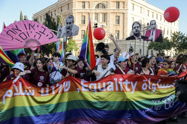 Participants march with a giant pride flag during the annual Jerusalem Pride Parade in the city centre