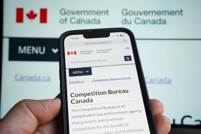 The government's Competition Bureau website is pictured on a mobile phone and laptop screen in Ottawa on Monday, Oct. 2, 2023. THE CANADIAN PRESS/Sean Kilpatrick