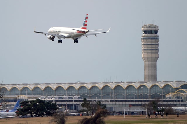 An American Airlines Embraer ERJ-190AR airplane flies past the tower where air traffic controllers work despite not receiving their paychecks, on the 22nd day of a partial government shutdown at Reagan National Airport in Washington, U.S., January 12, 2019. REUTERS/Joshua Roberts/File Photo