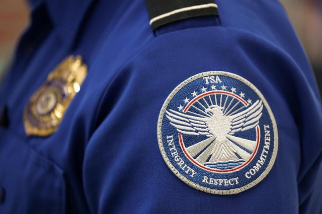 A TSA agent wears a patch on his uniform at the Miami International Airport on December 17 in Miami, Florida.