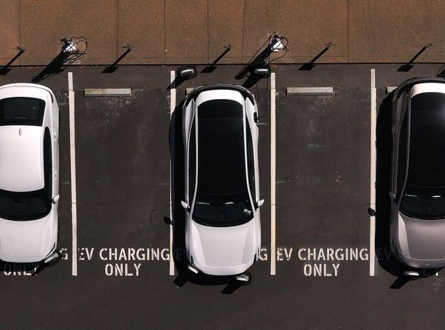 In an aerial view, electric cars sit parked at a charging station on May 19, 2025 in Corte Madera, California. Republican lawmakers in Washington DC are poised to vote on waivers that allow California to set its own emission standards.