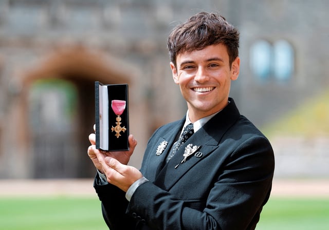 Tom Daley poses with his OBE (Officer of the Order of the British Empire) for services to diving, as well as in recognition of his charity work and his support of LGBTQ+ rights following an investiture ceremony at Windsor Castle, Britain July 12, 2022. Andrew Matthews/Pool via REUTERS/File Photo