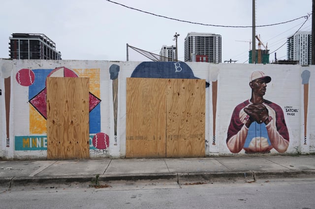 Murals of baseball legends Minnie Miñoso, left, and Jackie Robinson, center, are covered with plywood after being defaced in Miami's Overtown neighborhood, Thursday, June 5, 2025, in Miami. (AP Photo/Lynne Sladky)