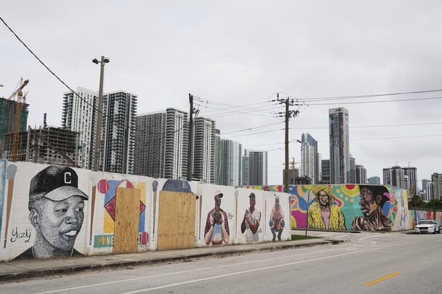 Murals of baseball legends Minnie Miñoso, second from left, and Jackie Robinson, third from left, are covered with plywood after being defaced in Miami's Overtown neighborhood, Thursday, June 5, 2025, in Miami. (AP Photo/Lynne Sladky)