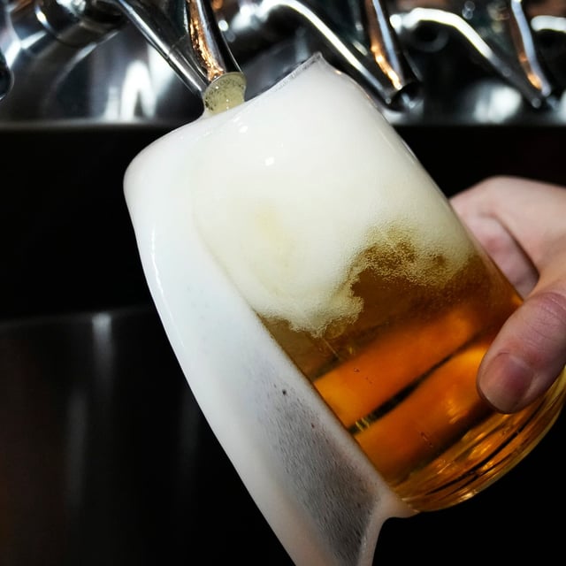 Alberta has ditched a brand new fee schedule for beer makers citing U.S. tariffs and a need to support business growth. A bartender pours a craft beer in Buffalo Grove, Ill., Thursday, Feb. 9, 2022. THE CANADIAN PRESS/AP/Nam Y. Huh