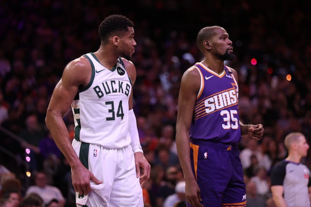 PHOENIX, ARIZONA - MARCH 24: Giannis Antetokounmpo #34 of the Milwaukee Bucks and Kevin Durant #35 of the Phoenix Suns look on during the second half of the NBA game at PHX Arena on March 24, 2025 in Phoenix, Arizona.