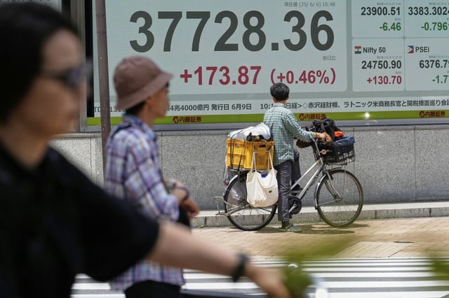 A person looks at an electronic stock board showing Japan's Nikkei index at a securities firm Friday, June 6, 2025, in Tokyo. (AP Photo/Eugene Hoshiko)