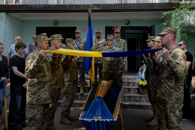 Des soldats ukrainiens déploient le drapeau national ukrainien sur le cercueil du militaire ukrainien de 21 ans Fedir Epifanov, tué dans la bataille près de la direction de Zaporizhzhia (Kiev, le 2 juin 2025).