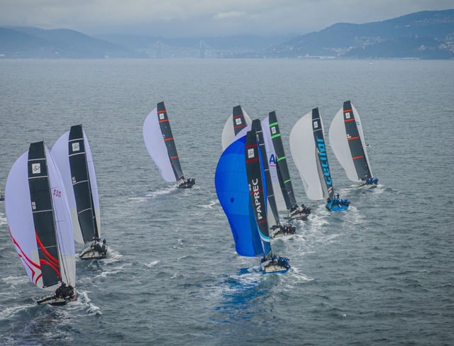 La flota despliega
sus spinnakers,
con Rande al fondo. 
|  Jacobo Bastos