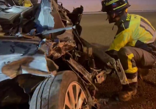 Un Bombero del Ayuntamiento de Madrid junto a uno de los coches destrozados