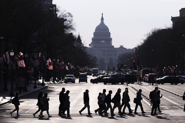 Commuters cross Pennsylvania Avenue in Washington, DC, during the morning rush hour on March 20.