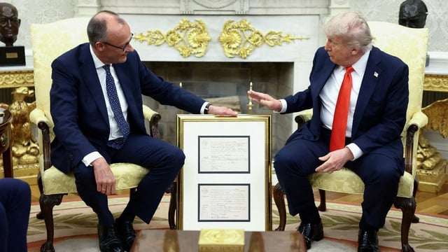 German Chancellor gifts Trump his grandfather's birth certificate at Oval Office