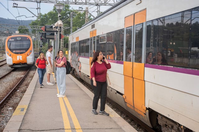 Imagen de archivo de pasajeros junto a un tren de Rodalies.