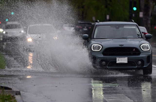 Cars spray large amounts of standing water at an intersection along York street in Denver on May 6, 2025. Rain is forecast for the rest of the day into tomorrow morning. (Photo by Helen H. Richardson/The Denver Post)