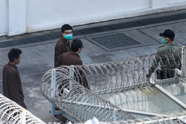 Joshua Wong (C), pictured here in 2020, became a household name during student-led protests over a decade ago
