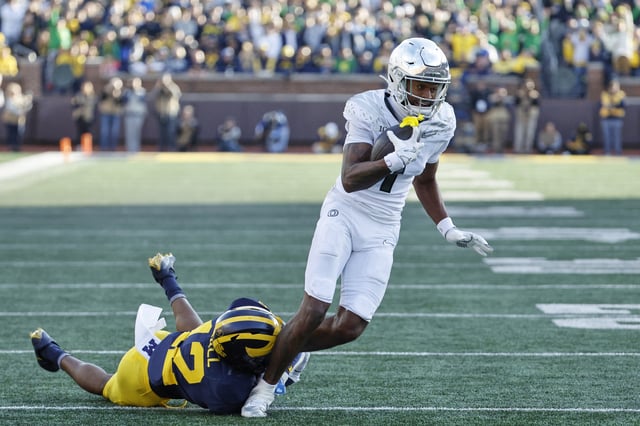 Nov 2, 2024; Ann Arbor, Michigan, USA;  Oregon Ducks wide receiver Evan Stewart (7) is tackled by Michigan Wolverines defensive back Aamir Hall (12) in the first half at Michigan Stadium. Mandatory Credit: Rick Osentoski-Imagn Images/File Photo