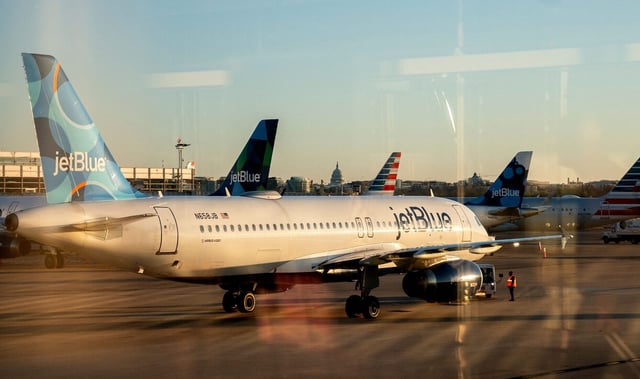 A JetBlue airplane at Ronald Reagan Washington National Airport in Arlington, Virginia, on March 9, 2023. - The US Justice Department on March 7, 2023, sued to block the $3.8 billion JetBlue-Spirit airline merger, saying that the combination would harm consumers and violate antitrust law. (Photo by Stefani Reynolds / AFP) (Photo by STEFANI REYNOLDS/AFP via Getty Images)