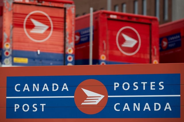 Canada Post signage and parked vehicles are seen at a Canada Post mail sorting facility in Ottawa, on Monday, Nov. 18, 2024. 