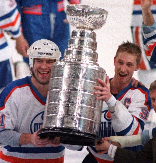 Edmonton Oilers' Wayne Gretzky, right, and Mark Messier hold up the Stanley Cup trophy, May 26, 1988 following their 6-3 win over the Boston Bruins in the Stanley Cup Finals in Edmonton.