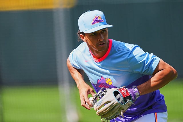 Colorado Rockies shortstop Ryan Ritter warms up before making his Major League debut in a baseball game against the New York Mets, Friday, June 6, 2025, in Denver. (AP Photo/David Zalubowski)