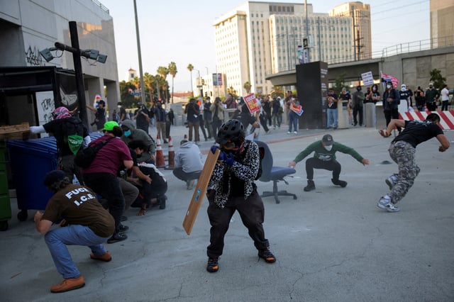 Protesters blocking the garage entrance of the Los Angeles Federal Building react as police fires pepper spray at them following multiple detentions by Immigration and Customs Enforcement (ICE), in downtown Los Angeles, California, U.S., June 6, 2025. REUTERS/Daniel Cole