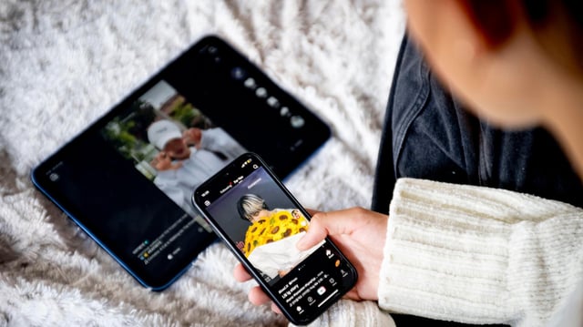 Ein Mädchen schaut sich TikTok-Videos auf ihrem Smartphone und Tablet an.