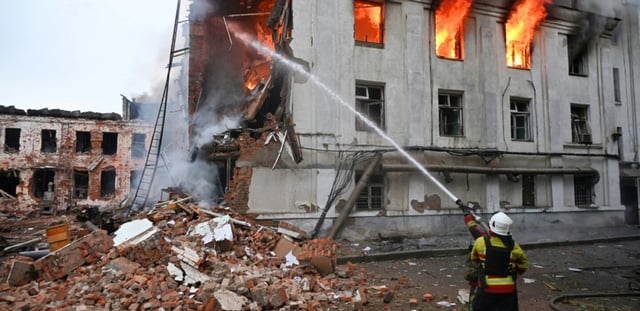 Un pompier lutte contre un incendie dans un bâtiment après une série d'attaques russes contre la ville de Kharkiv, dans l'est de l'Ukraine, le 7 juin 2025