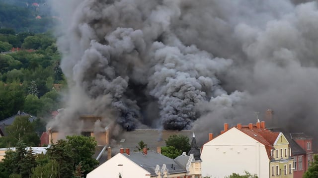 Dichte Rauchwolken sind bei einem Großbrand im früheren Domizil der Staatsoperette in Dresden-Leuben zu sehen