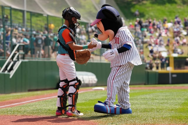 Jesus Diaz, with the Latin America Region team from Barquisimeto, Venezuela meets with Mickey Mouse after throwing a ceremonial first pitch before the International Championship game during the Little League World Series in South Williamsport, Pennsylvania on Aug. 24, 2024.