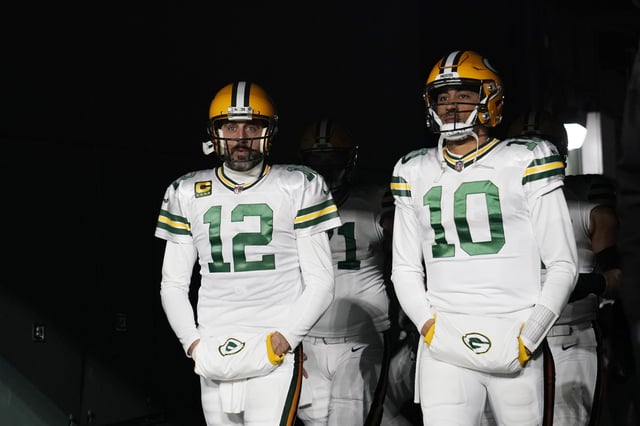 Aaron Rodgers #12 and Jordan Love #10 of the Green Bay Packers walk onto the field prior to the game against the Tennessee Titans at Lambeau Field on November 17, 2022 in Green Bay, Wisconsin.