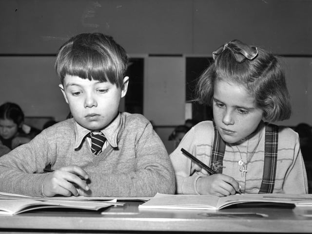 10th January 1956: Two pupils from Putney Vale Heathmere Primary School, hard at work at their desks. (Photo by Derek Berwin/Fox Photos/Getty Images)