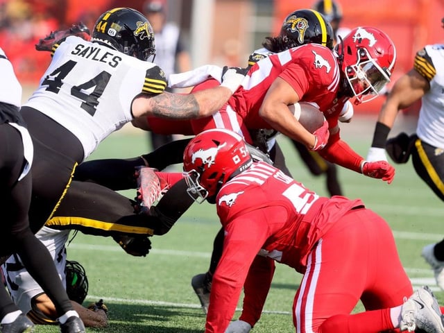  Stampeders receiver Jalen Philpot is pursued by Tiger-Cats defensive lineman Casey Sayles on Saturday.