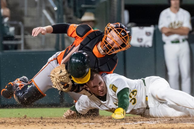 Baltimore Orioles catcher Maverick Handley, left, tags out Athletics&#39; JJ Bleday (33) during the fifth inning of a baseball game Saturday, June 7, 2025, in West Sacramento, Calif. (AP Photo/Sara Nevis)